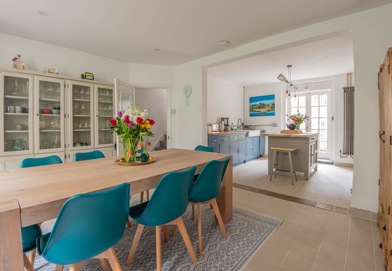 Dining room with a long timber table and teal chairs