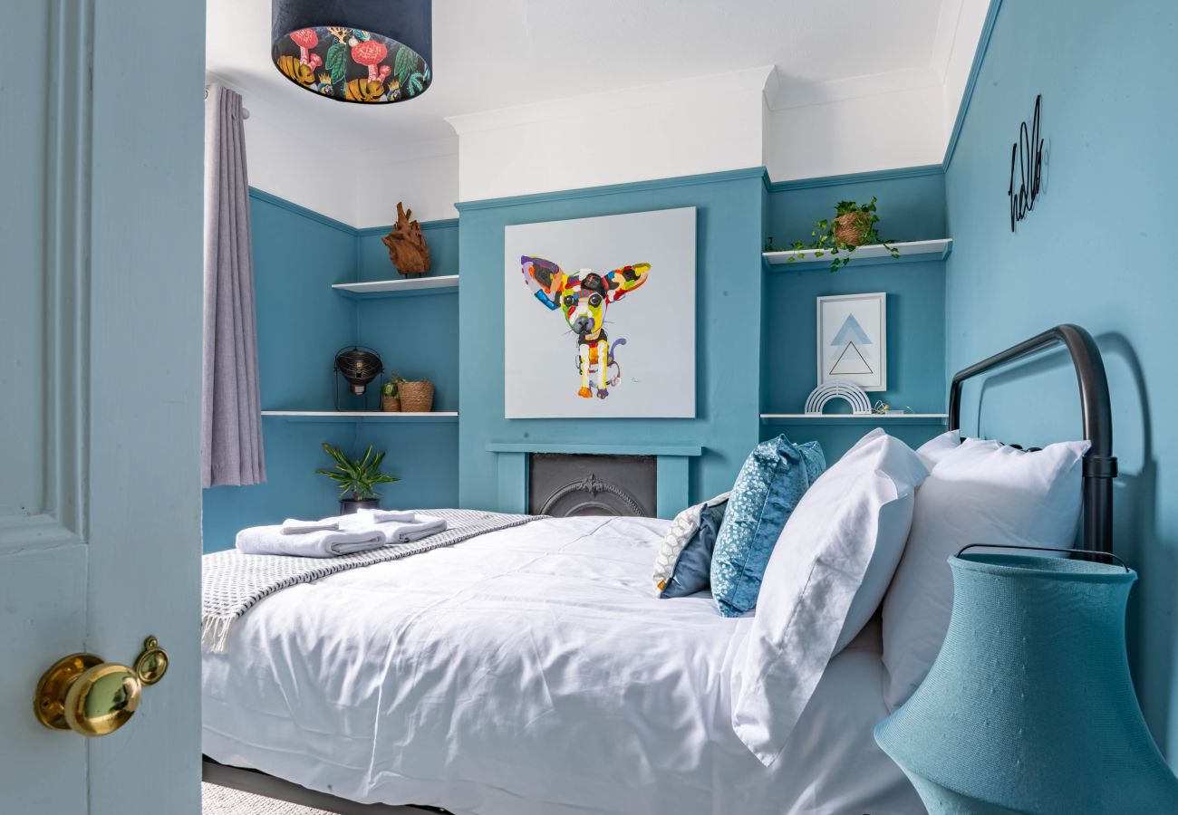 Teal bedroom seen through its open doorway